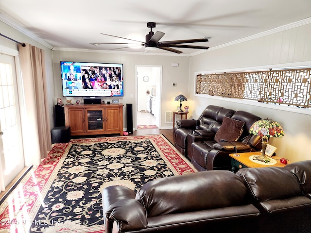 living area with ornamental molding, a ceiling fan, and wood finished floors