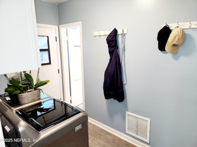 interior space featuring washing machine and dryer, visible vents, and baseboards