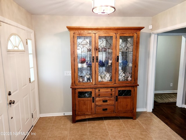 entryway with light tile patterned flooring and baseboards