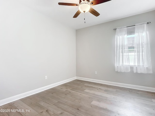 spare room featuring light wood-style floors, baseboards, and a ceiling fan