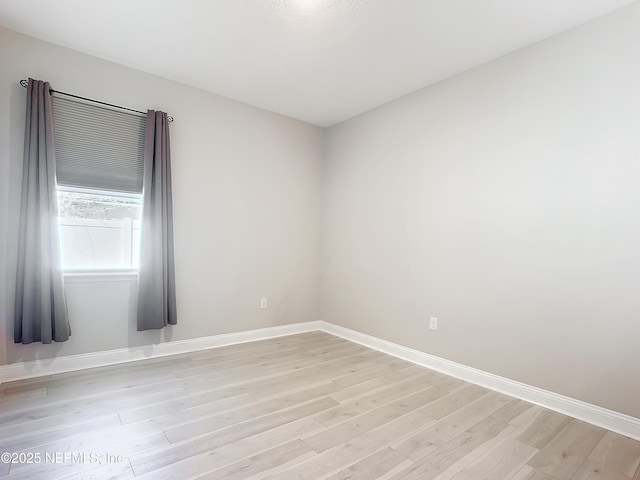 empty room featuring light wood-style floors and baseboards