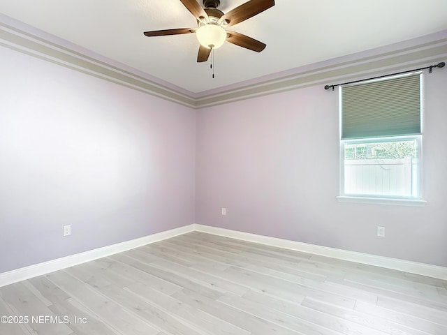 empty room featuring light wood finished floors, crown molding, baseboards, and a ceiling fan