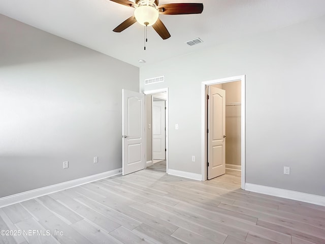 unfurnished bedroom with visible vents, light wood-style flooring, and baseboards