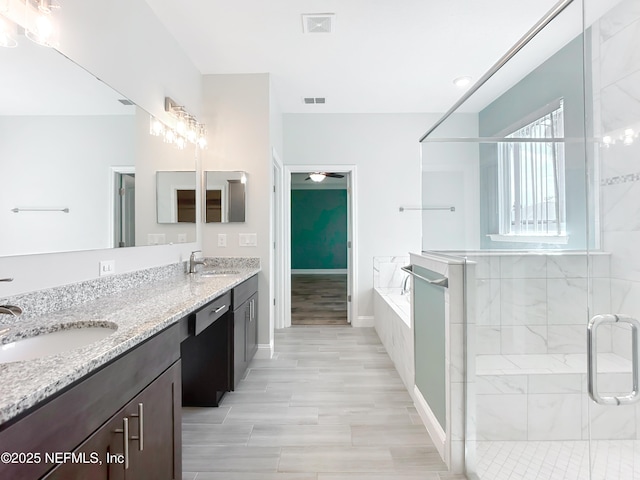 bathroom featuring a bath, a sink, visible vents, and a shower stall