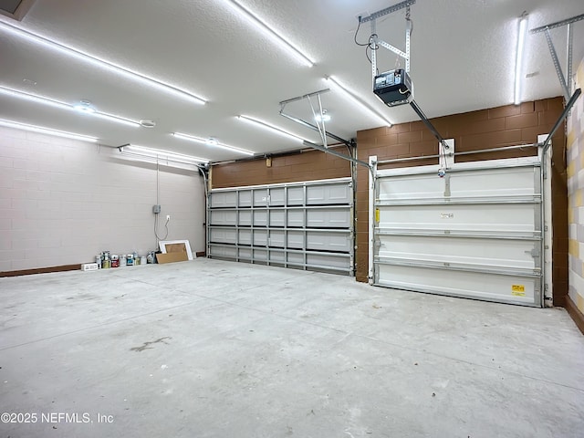 garage featuring concrete block wall and a garage door opener