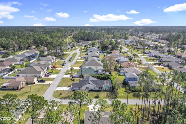 drone / aerial view featuring a residential view and a view of trees