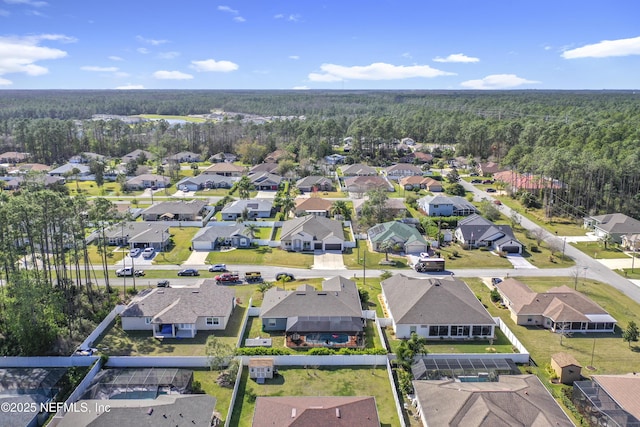 aerial view featuring a forest view and a residential view