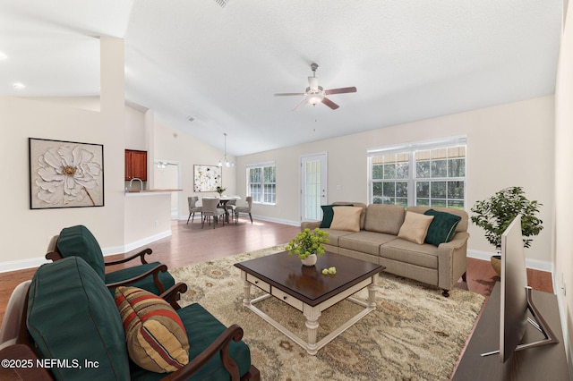 living room with lofted ceiling, ceiling fan, wood finished floors, and baseboards