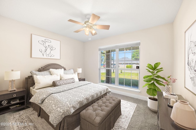 carpeted bedroom with ceiling fan and baseboards