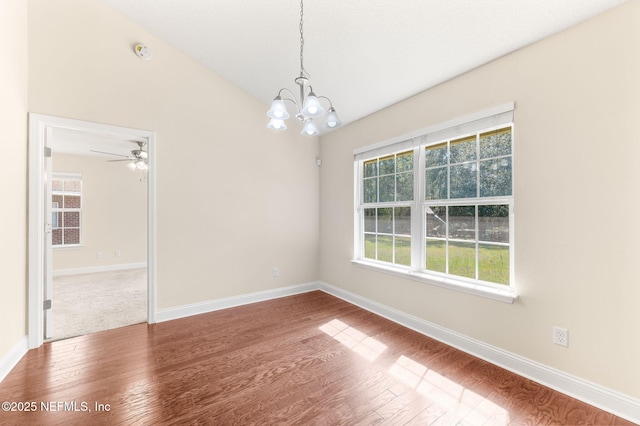 unfurnished room with baseboards, vaulted ceiling, and wood finished floors