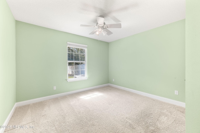 carpeted empty room featuring ceiling fan, a textured ceiling, and baseboards