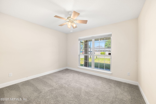 spare room with carpet floors, ceiling fan, and baseboards