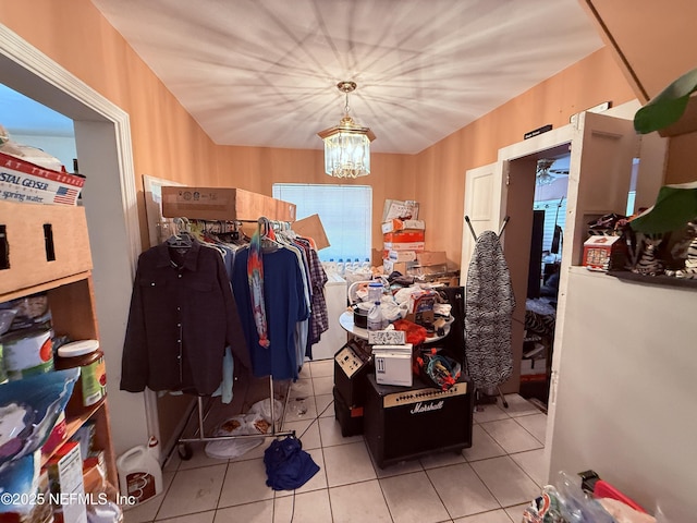 spacious closet with light tile patterned floors and an inviting chandelier