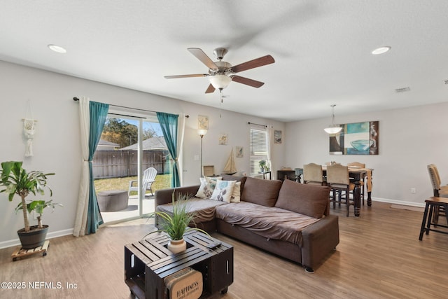 living room with recessed lighting, wood finished floors, visible vents, and baseboards