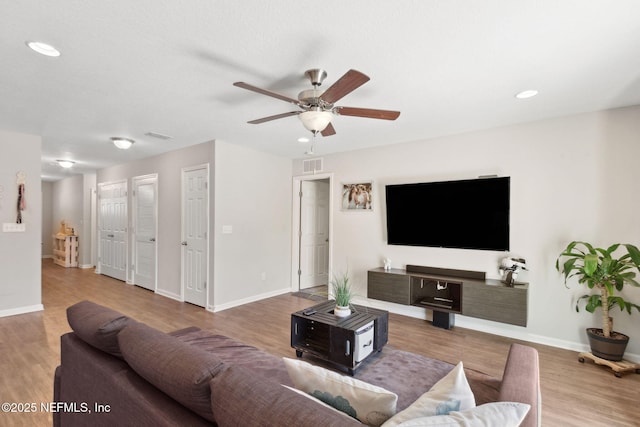 living room featuring recessed lighting, visible vents, a ceiling fan, wood finished floors, and baseboards