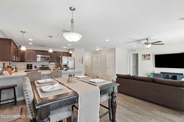 dining space with a ceiling fan, recessed lighting, visible vents, and light wood finished floors