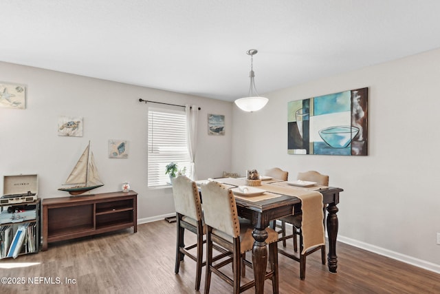 dining space with baseboards and wood finished floors