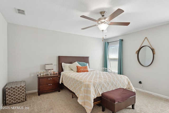 bedroom with a ceiling fan, light carpet, visible vents, and baseboards