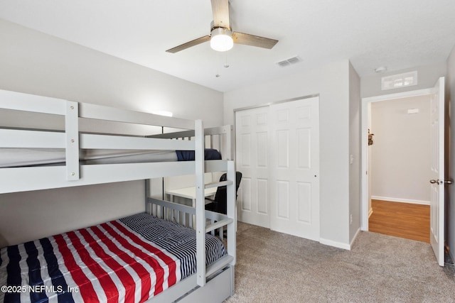 carpeted bedroom with a closet, visible vents, ceiling fan, and baseboards