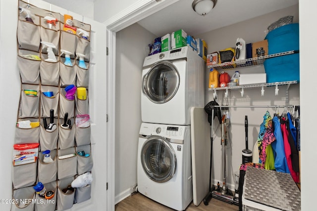 clothes washing area with stacked washer / dryer, laundry area, and wood finished floors