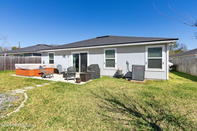 rear view of property featuring central AC, a lawn, a fenced backyard, and stucco siding