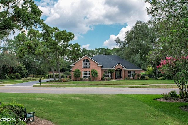 view of front of home featuring brick siding and a front yard