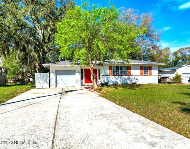 ranch-style home featuring an attached garage, concrete driveway, and a front yard