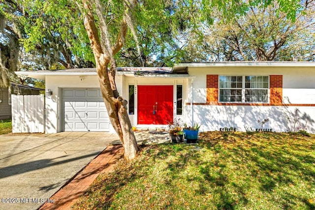 ranch-style house featuring a front yard, concrete driveway, and an attached garage