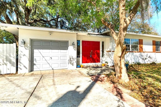 single story home with a garage, driveway, and fence