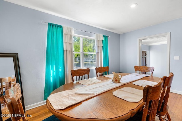 dining space featuring light wood-style flooring and baseboards