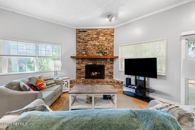 living room featuring a brick fireplace, wood finished floors, a healthy amount of sunlight, and ornamental molding