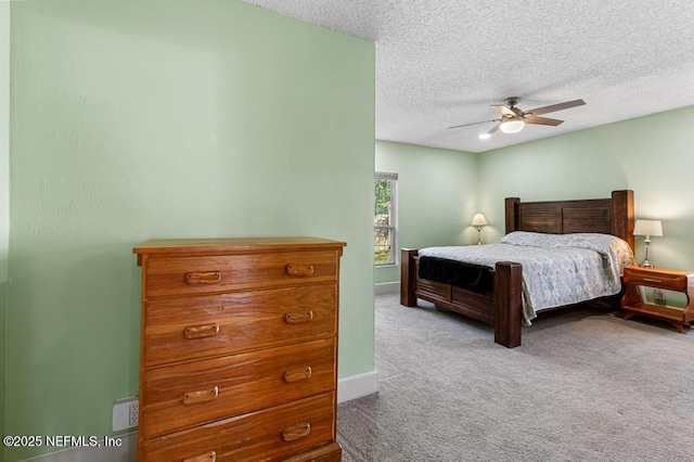 carpeted bedroom featuring baseboards, a textured ceiling, and ceiling fan