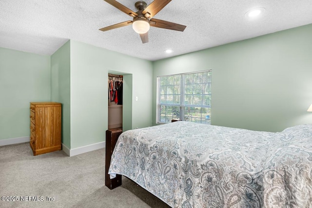 bedroom featuring light carpet, a ceiling fan, a textured ceiling, recessed lighting, and baseboards