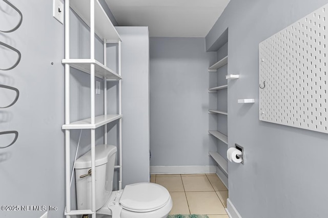 bathroom featuring baseboards, toilet, and tile patterned flooring