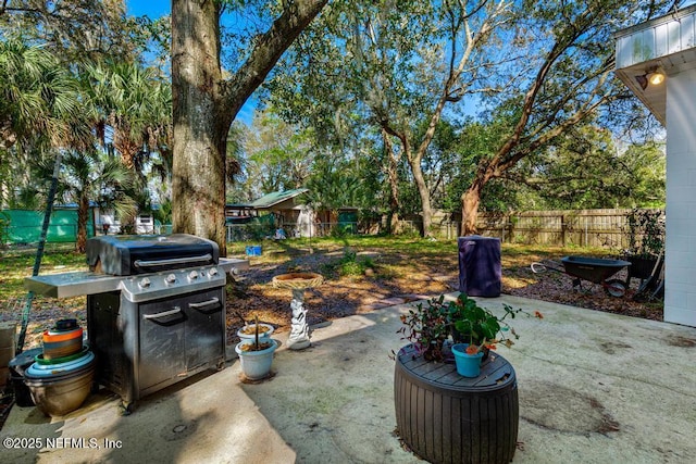 view of patio with area for grilling and fence