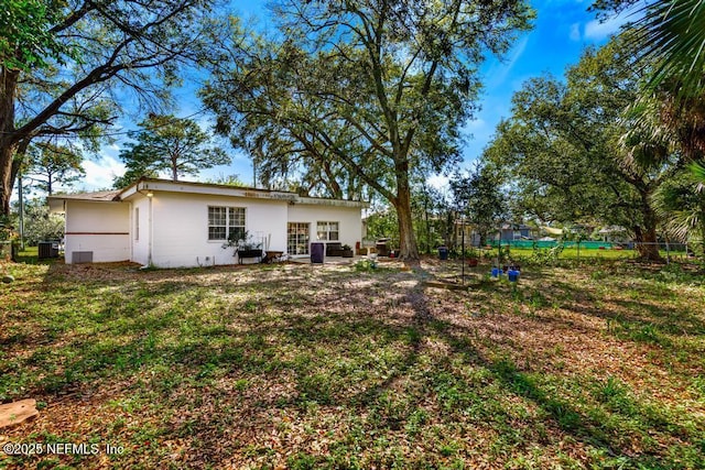 view of yard featuring fence and central AC