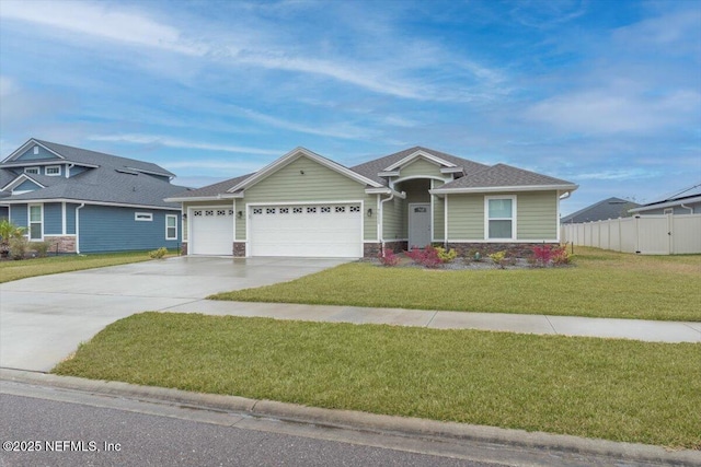 view of front of house with driveway, stone siding, an attached garage, fence, and a front yard