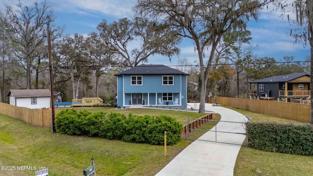 view of front of home with a fenced front yard, a gate, a porch, and a front yard