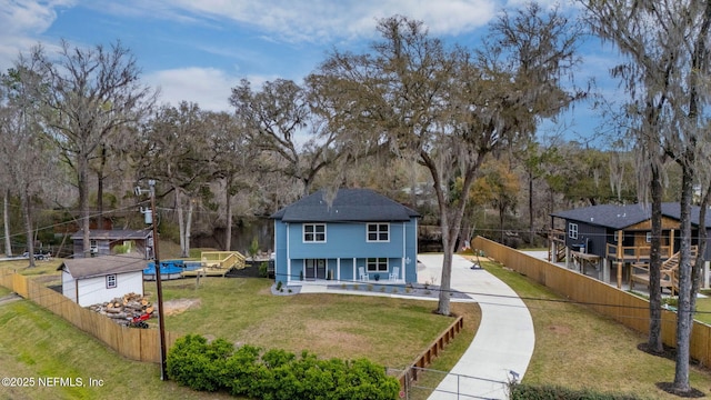 view of front of property featuring covered porch, a front lawn, and fence private yard