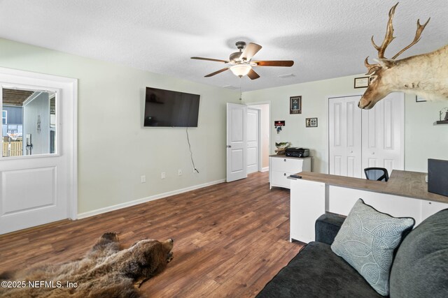 living area with baseboards, visible vents, ceiling fan, wood finished floors, and a textured ceiling