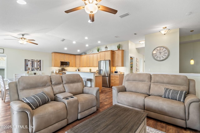 living room with lofted ceiling, ceiling fan, recessed lighting, wood finished floors, and visible vents