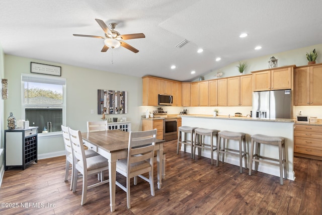 dining room with dark wood finished floors, visible vents, vaulted ceiling, a textured ceiling, and ceiling fan