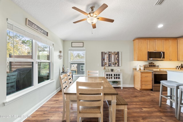 dining space with dark wood-style floors, visible vents, a textured ceiling, and baseboards