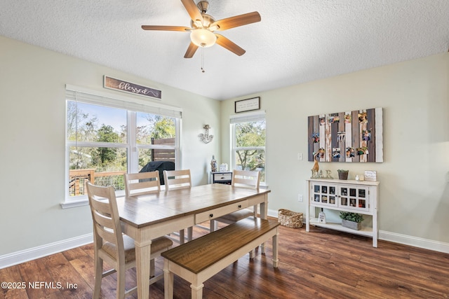 dining space featuring a textured ceiling, ceiling fan, wood finished floors, and baseboards