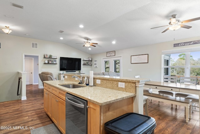 kitchen with vaulted ceiling, open floor plan, visible vents, and a sink