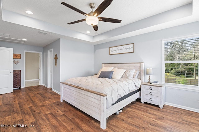 bedroom with baseboards, visible vents, and wood finished floors