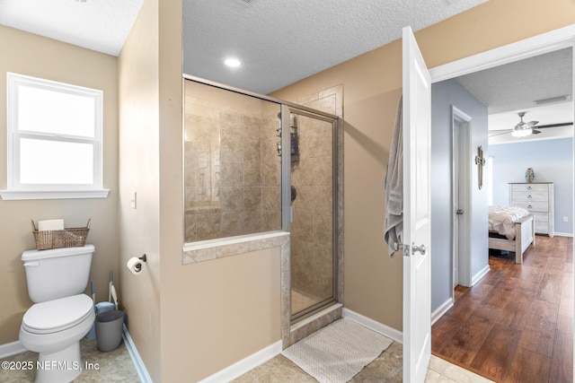 ensuite bathroom with a textured ceiling, a stall shower, visible vents, and baseboards