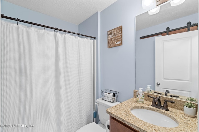 bathroom featuring toilet, curtained shower, a textured ceiling, and vanity