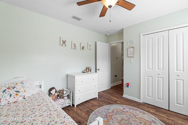 bedroom with a textured ceiling, a closet, wood finished floors, and visible vents