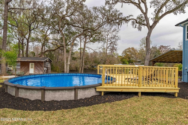 outdoor pool featuring an outbuilding and a wooden deck